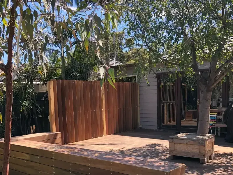 A photo of an exterior renovation including a fence and a deck.